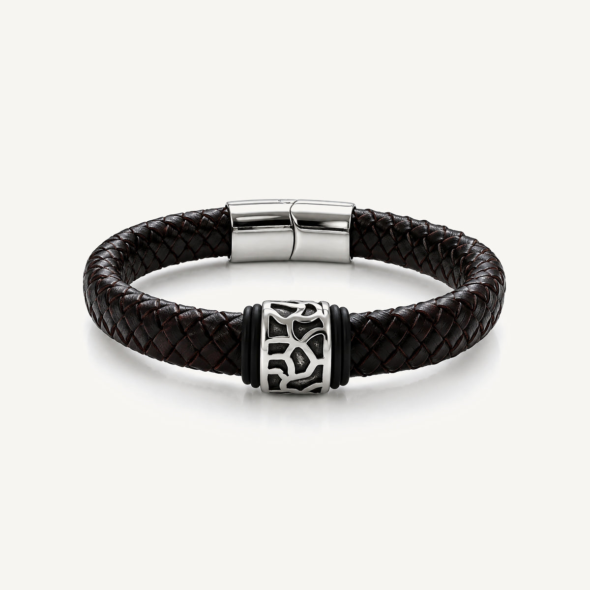Pulsera Cuero Trenzado Vulcano de cuero negro con aplique central de acero inoxidable texturizado y bandas de silicona negra.