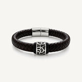 Pulsera Cuero Trenzado Vulcano de cuero negro con aplique central de acero inoxidable texturizado y bandas de silicona negra.