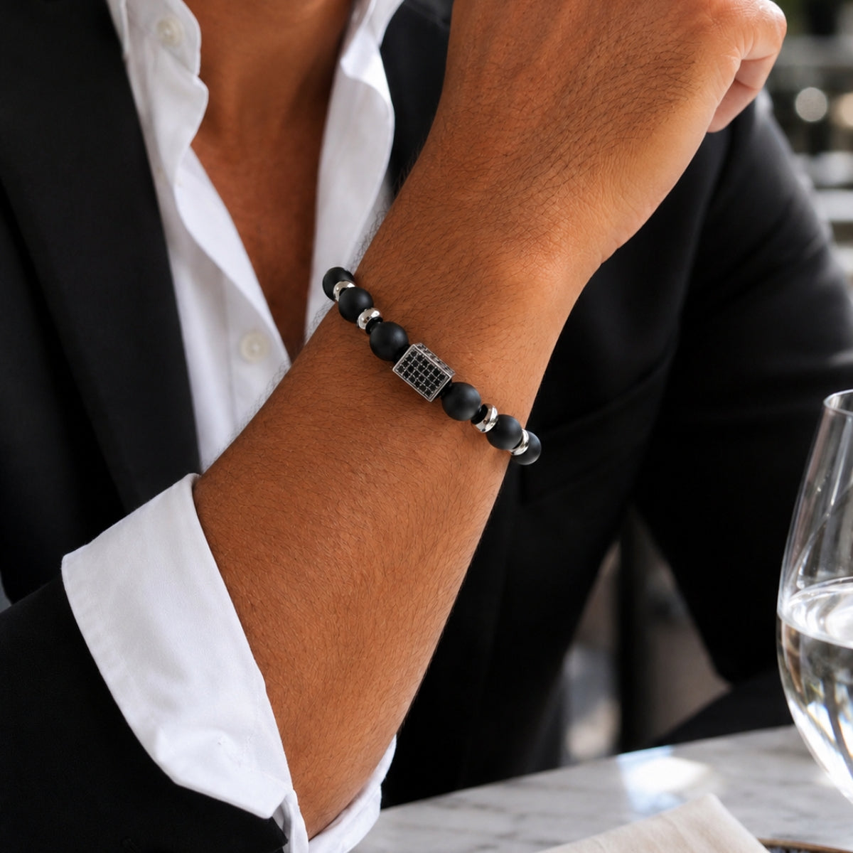 modelo con Pulsera Noir de ónix mate natural con piedras de 10 mm y 8 mm y accesorios de acero inoxidable para hombre.