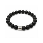 Pulsera elástica para hombre modelo Orión con hilo de silicona, esferas de Onix Negro y tubo cilíndrico central de plata 925 sobre fondo blanco.