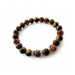 Pulsera elástica para hombre modelo Hermes con hilo de silicona, esferas de ojo de tigre y tres aros texturizados de plata 925 sobre fondo blanco.