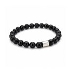 Pulsera elástica para hombre modelo Orión con hilo de silicona, esferas de turmalina negra pulida y tubo cilíndrico central de plata 925 sobre fondo blanco.