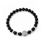 Pulsera elástica para hombre con esferas de piedra natural turmalina negra de 8 mm, hilo de silicona y medalla de San Benito en plata 925.